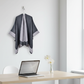 Dark gray and light gray cape hanging in office with laptop and flower