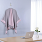 Gray and pink cape hanging in office with laptop and flower