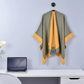 Olive green and yellow cape hanging in office with laptop and flower