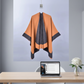 Orange and charcoal cape hanging in office with laptop and flower